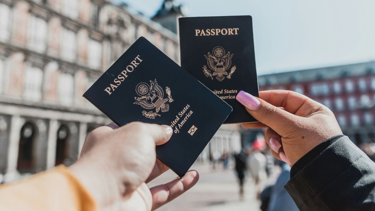 Two people holding passports in the air